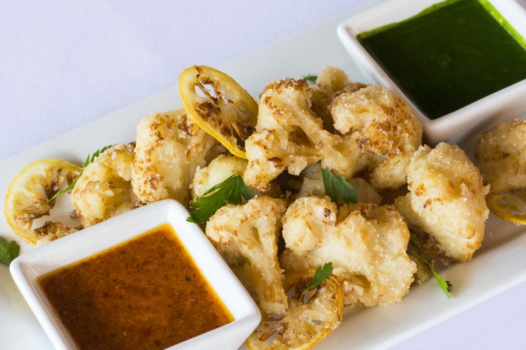 Crisp Cavolfiore for your #MeatlessMonday! This trendy plate features crispy fried cauliflower served with a lemon-basil pesto,and Calabrian tomato pesto.