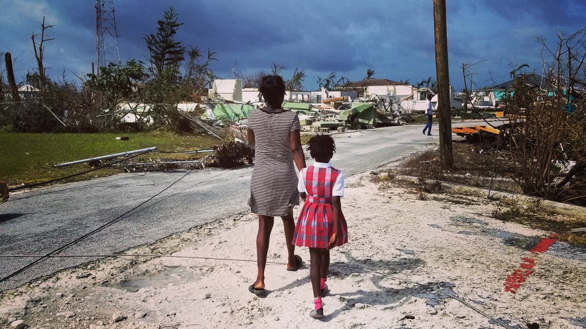 After. mother and daughter walk through the wreckage of their Marsh Harbour...