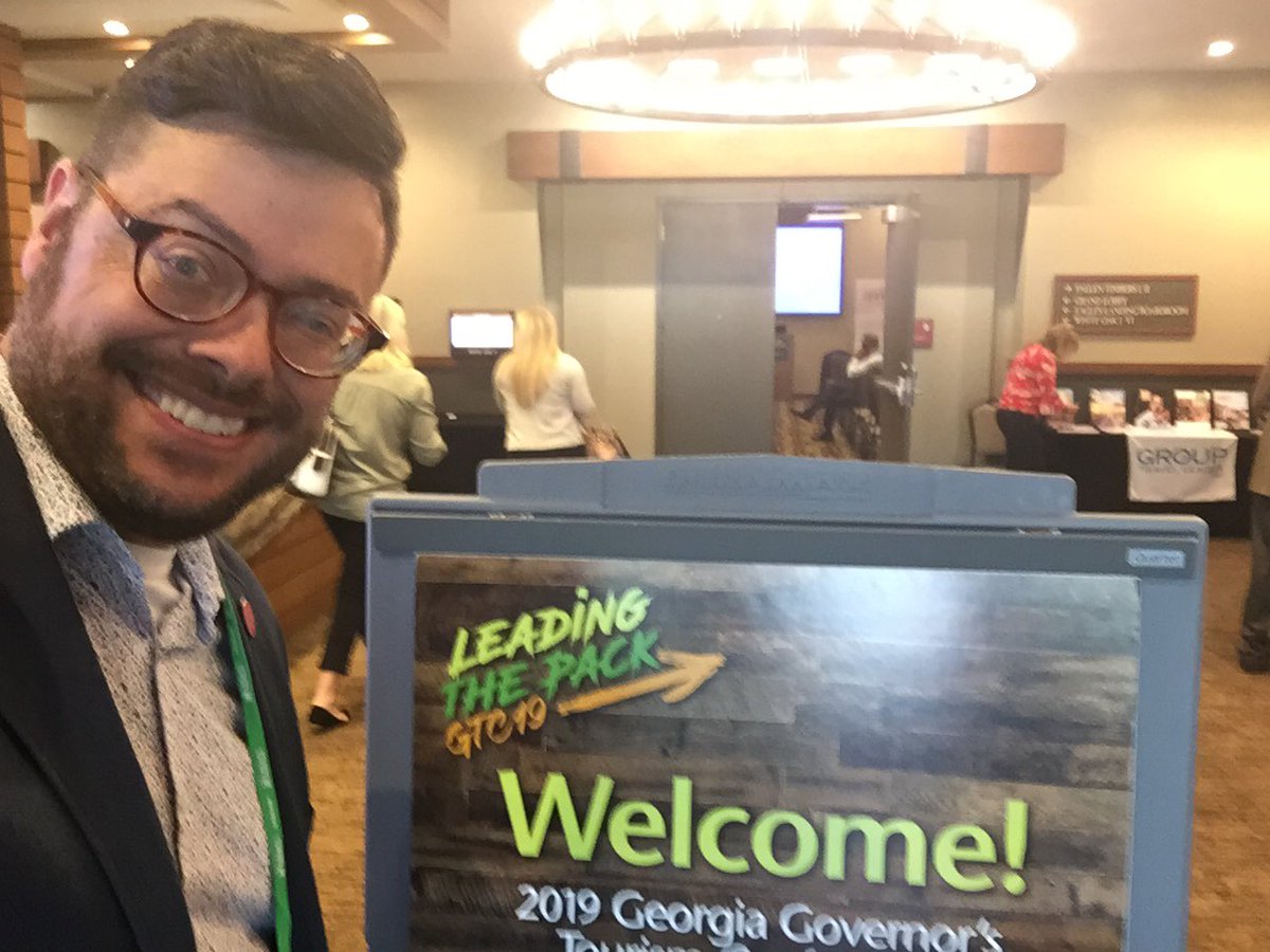 Speaking on accessible tourism at the Georgia Governor's Tourism Conference! [Image description - man smiling in front on conference signage] #disability #inclusion #tourism