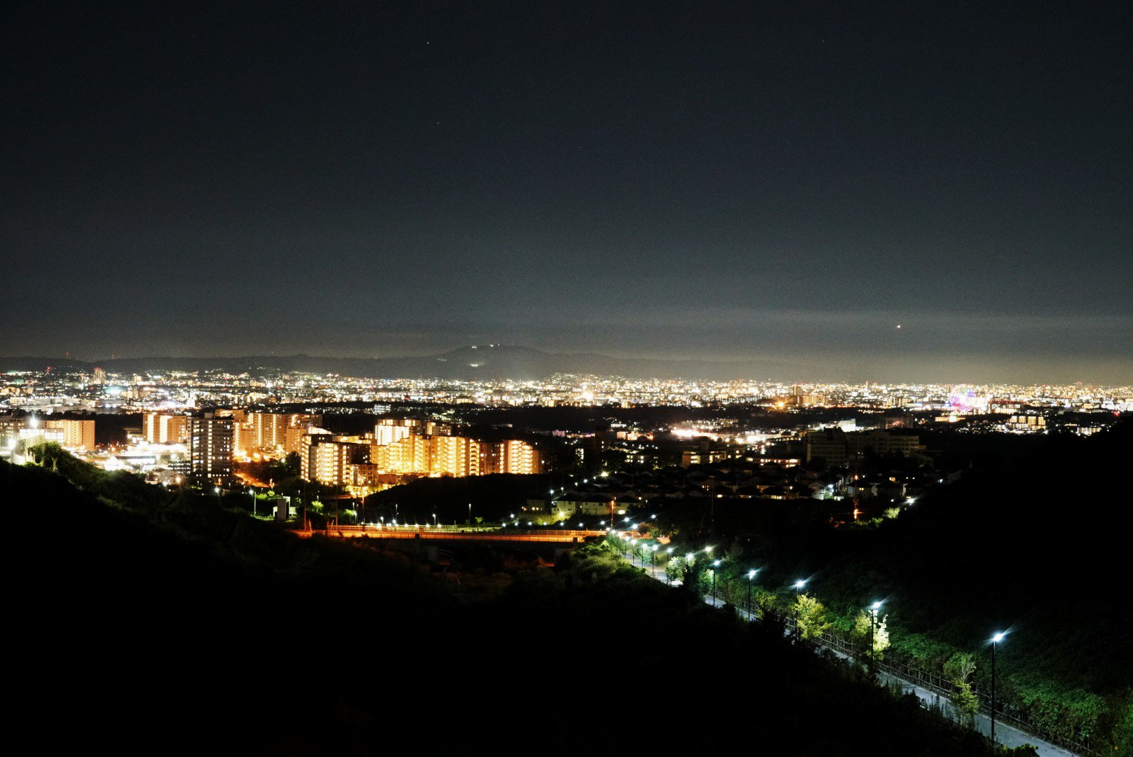 ムラカミ 大阪 彩都からの夜景 彩都なないろ公園の上の橋から撮影 住宅街なので周りは静か 公園上から始まって 下り坂の始まる約50メートルの間で夜景を楽しむことができます 夜景を見に来ているバイクや車がちらほら 大阪 夜景スポット 彩都 T