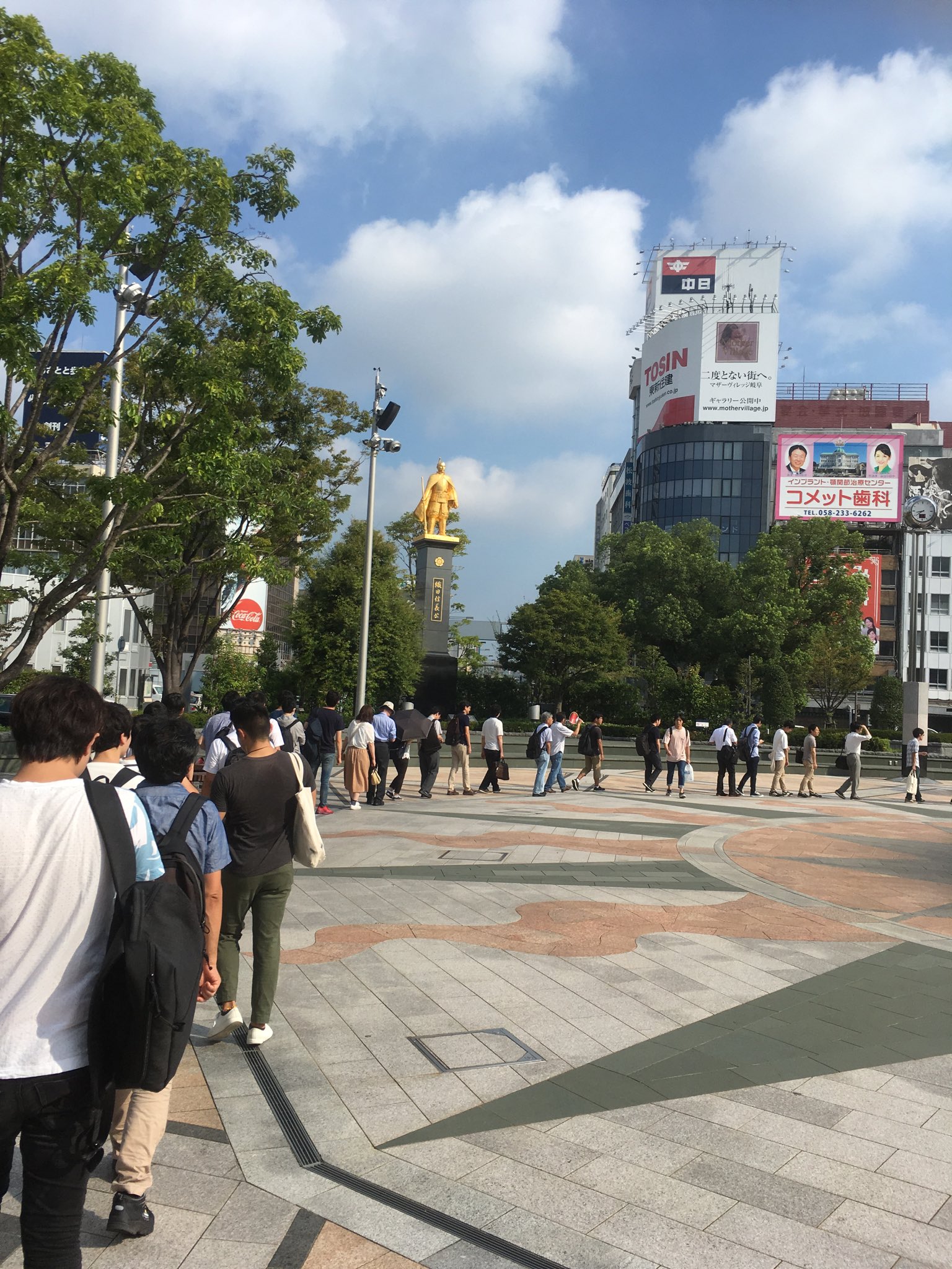 加藤岳生 朝 金ピカの織田信長像の前で行列を組む物理学者