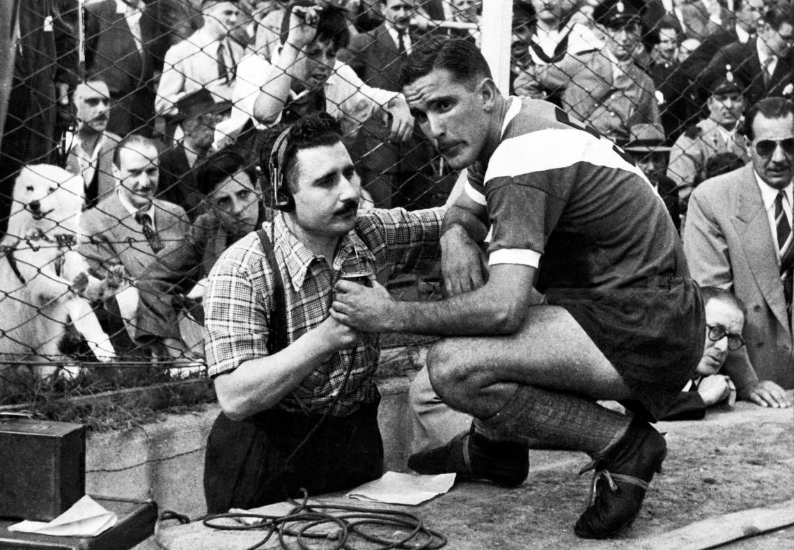 Centrojas's tweet photo. José Maria Muñoz, entrevista en campo de juego a Eliseo Mourinho, el perro blanco detrás apoyado con las patas en el alambre es lo mejor de la foto https://t.co/xAkOgEUiiM