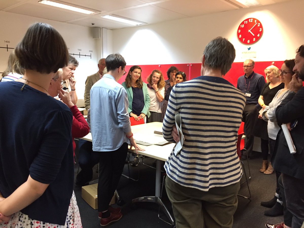 Volunteers standing around a table as Jen from #TNALearning shows us Elizabeth I’s Tide Letter.