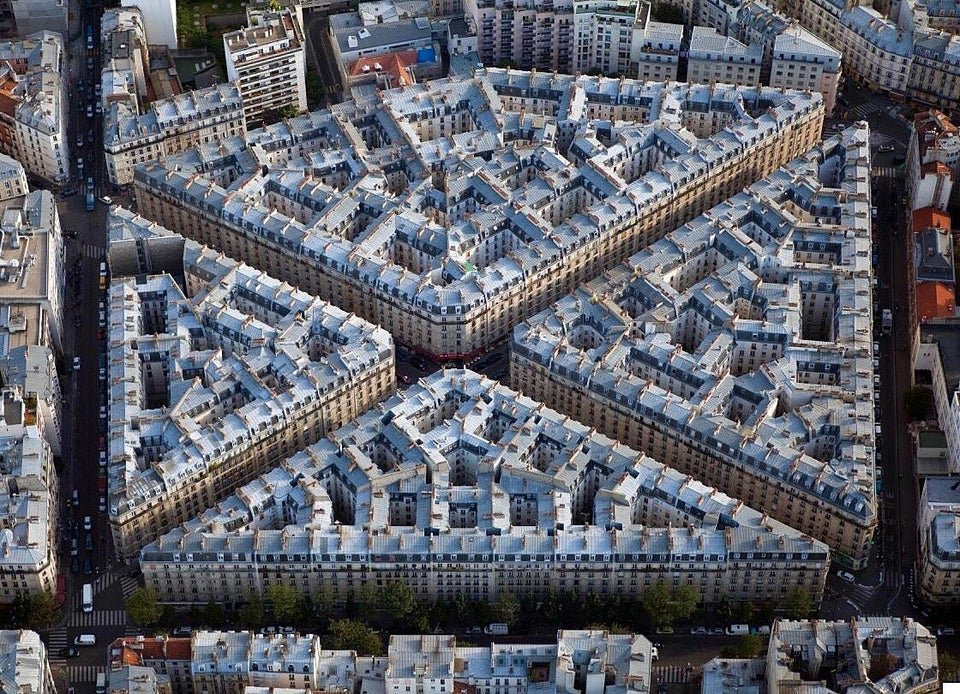 A Paris working class neighborhood. 3321 persons live here on 0.03km2, giving a pop. density of over 110K per square kilometer. The buildings are all 6+1 floors (the +1 being the later added mansard roof apartment floor). In the 18th, where Rue Simart and Rue Eugène Sue meets.
