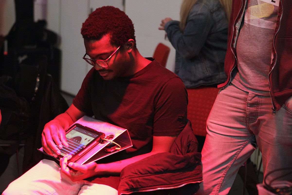 A young man plays an iPad like a guitar
