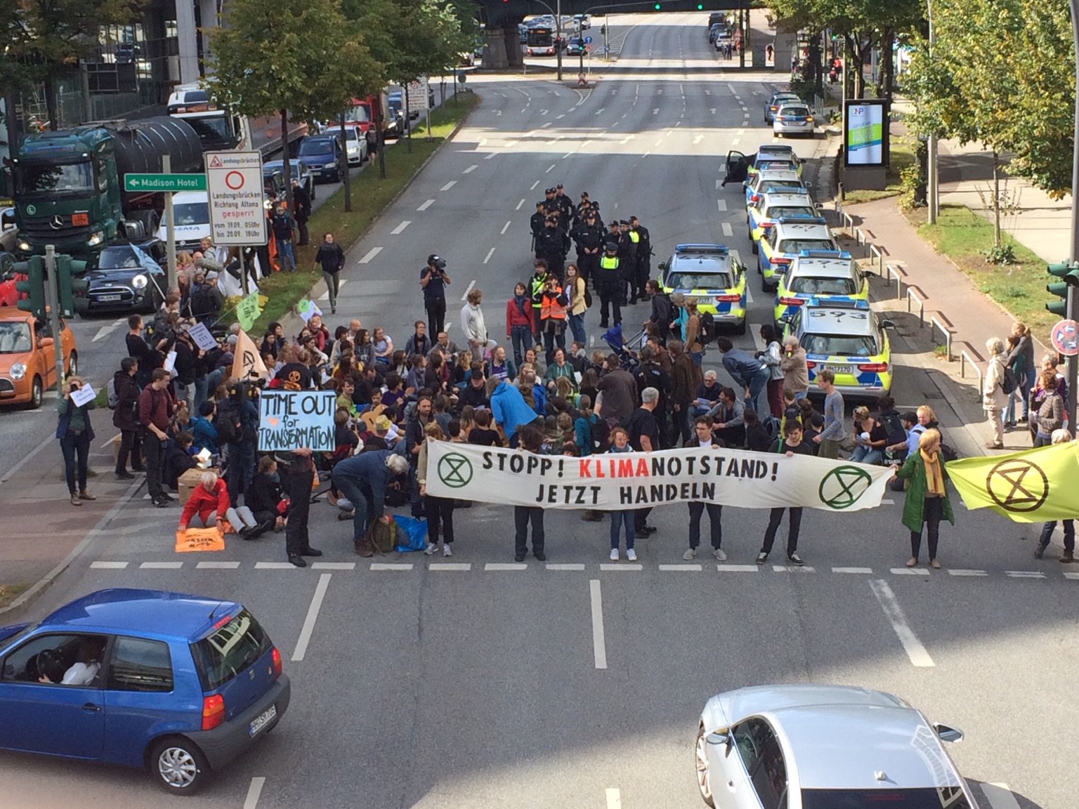 Demonstrierende Personen, die mit Bannern die Straße sperren