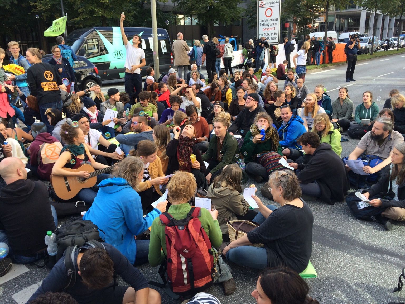 Auf der Straße sitzende Personen, die gemeinsam singen