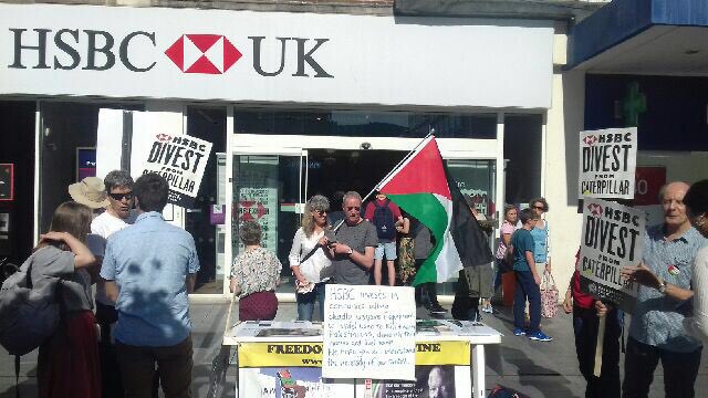 secretsurfer's tweet photo. Exeter PSC action today against #HSBComplicity with Israel’s arms trade. @HSBC must divest from @CaterpillarInc and #StopArmingIsrael https://t.co/kwos7t0z20 https://t.co/hf1Wx0UGRb