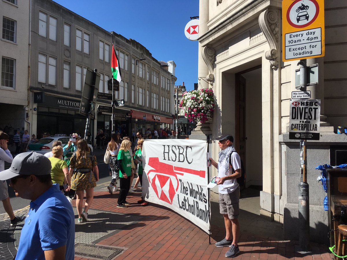 BrightonPSC's tweet photo. Brighton action protesting #HSBComplicity in Israel’s war crimes. Our die-in closed the main Brighton branch briefly and 100s of people stopped to take leaflets and learn more. Time for @hsbc to divest from @CaterpillarInc #StopArmingIsrael https://t.co/IXYXRaAYj6