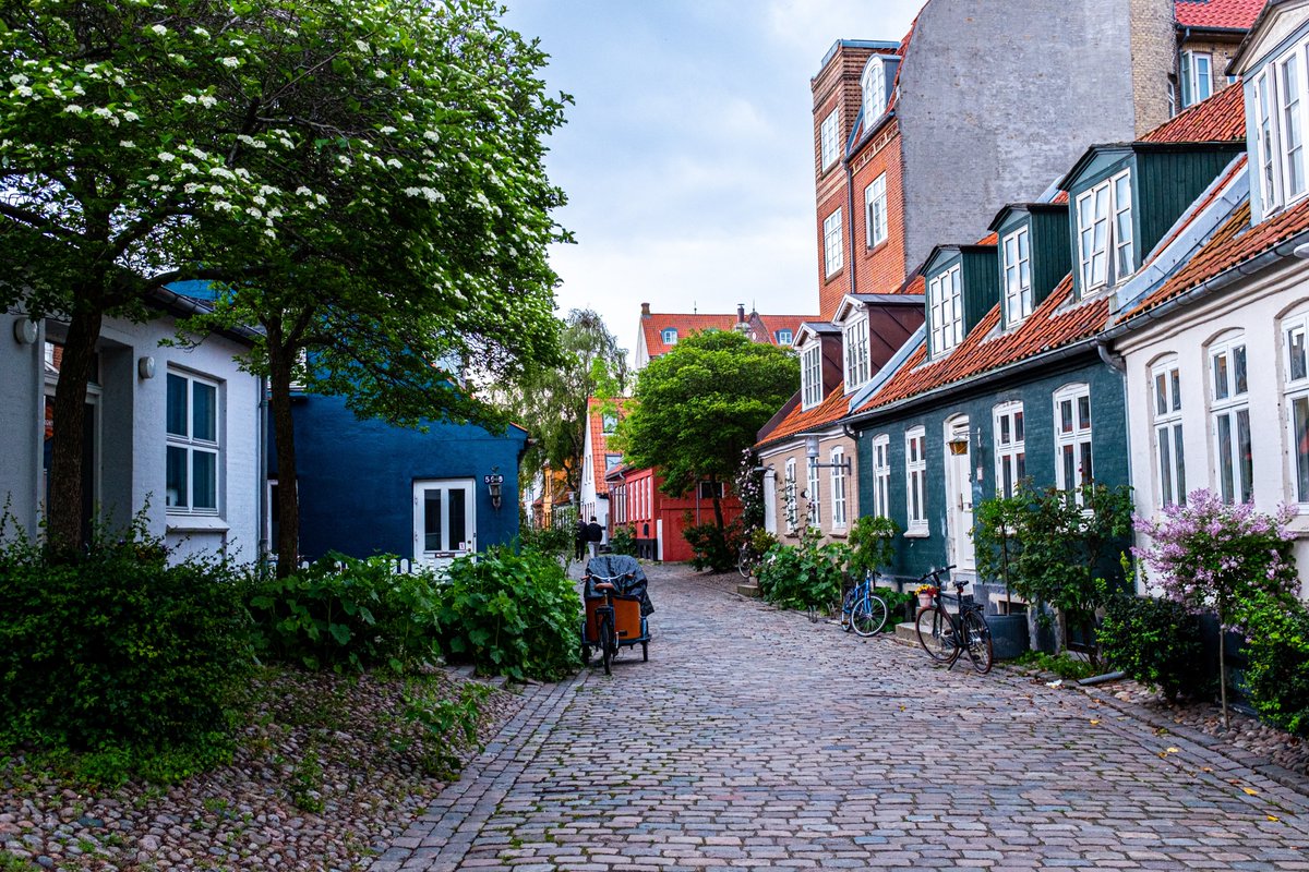 alkamilbooking's tweet photo. Møllestien (Aarhus), #Denmark - the prettiest cobblestone street in #Aarhus. The street is home to colorful houses dating from the 18th century. The houses are originally just one story with one or two windows and a door, and the style is called “outhouses” or “booths. https://t.co/HdsUAXbAc7