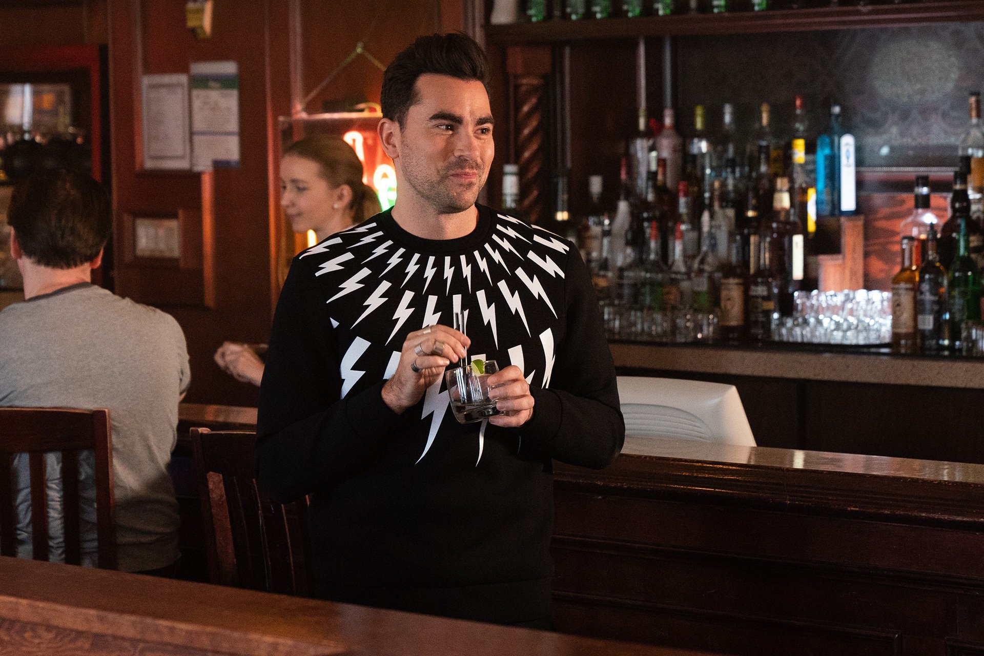 David at a bar in his sweater emblazoned with lightning bolts 