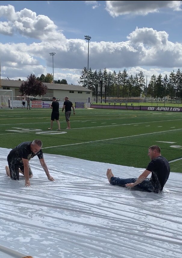 These guys are ALL IN. Campus Monitor Erik “Chief” Chosvig and Principal John Huelskamp slip and slide in front of Sunset’s students at Friday’s outdoor pep assembly.