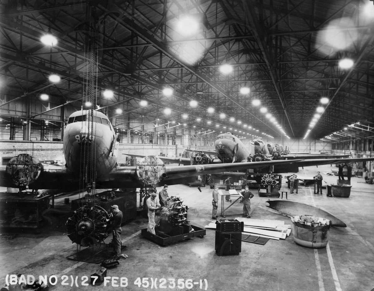 BAD2Warton's tweet photo. C-47 SkyTrains pictured lining Warton's 3 Hangar on 27th February 1945. The C-47 was a common sight at #BAD2; In addition to 125 of the type arriving for maintenance and modification, C-47s arrived daily to transport units and supplies to bases in the ETO. #WW2 #avgeek #history https://t.co/CzpjGdipTs