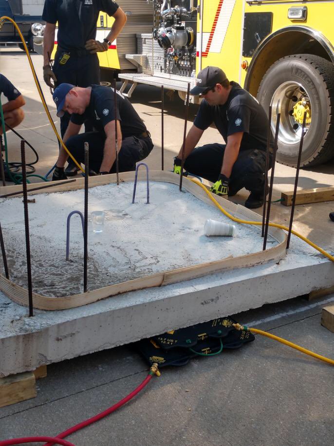 Members of CJC working on moving large objects with air bags, then using cribbing to keep it stable.