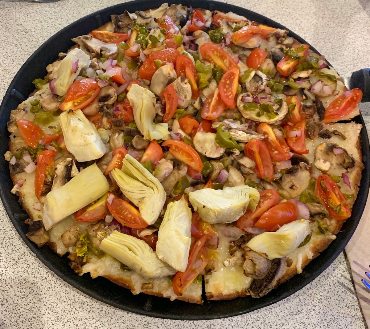 It's World Vegetarian Day! This is a veggie creation from one of our customers - mushrooms, tomatoes, jalapeños, red onions, half with artichokes, and olive oil on our gluten free crust. Looks like perfection to us!!