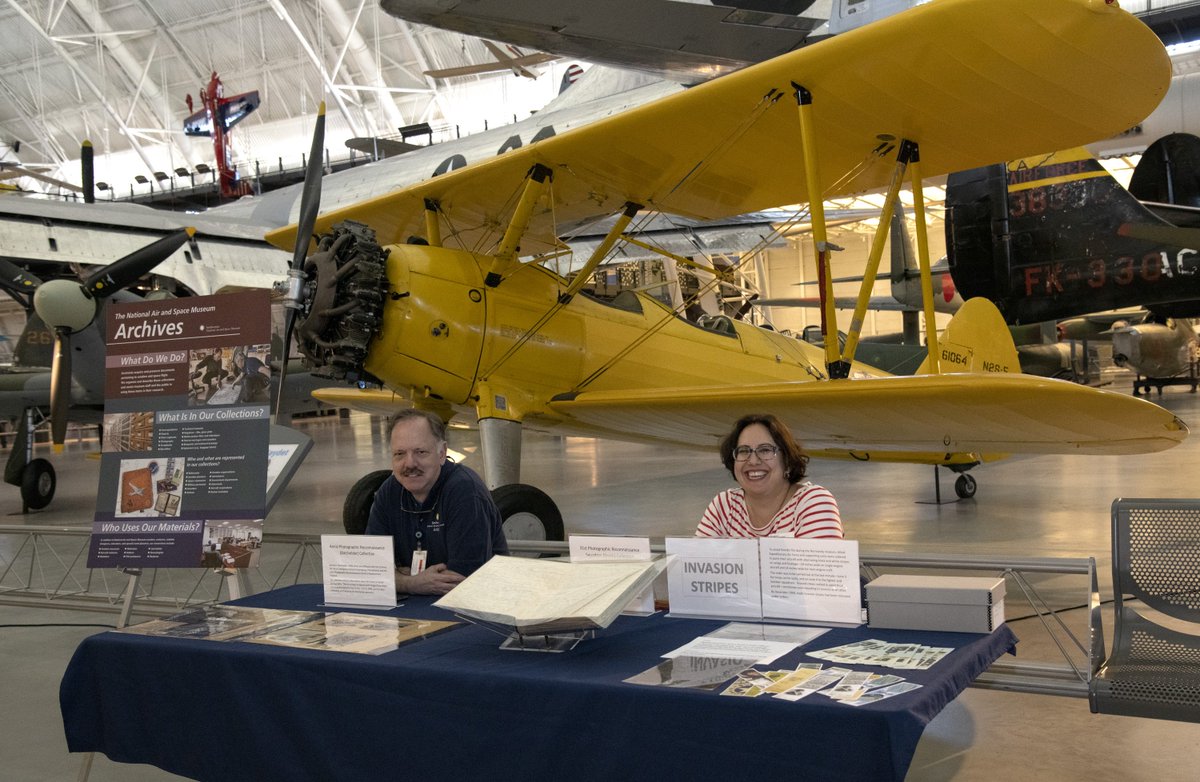 A man and woman sit behind table
