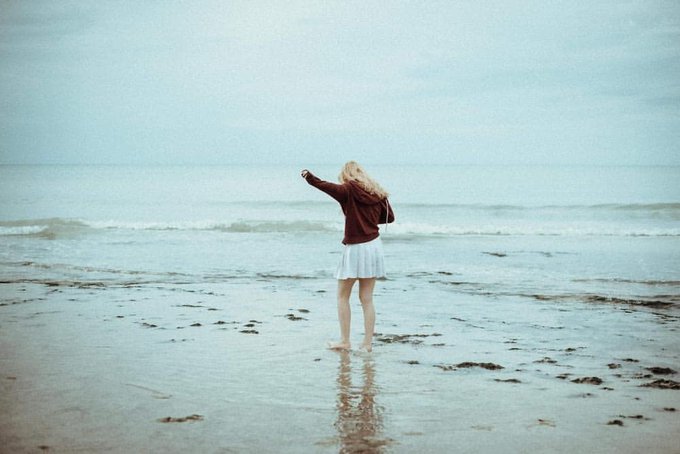 Seule sur le sable, les yeux dans l'eau.  Photos de Nuno Martins. https://t.co/sNuSsD6bCC