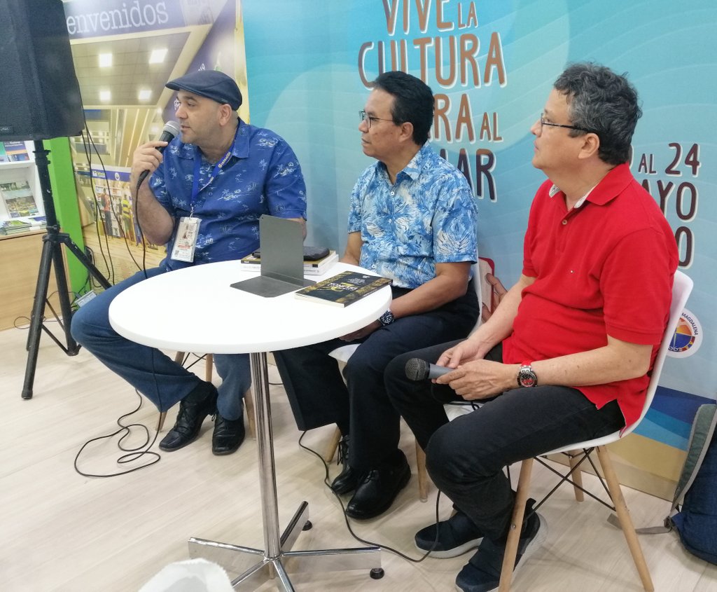 VInUnimagdalena's tweet photo. Clinton Ramírez y Guillermo Tedio representan al grupo de autores de "Cuentos Felinos 2" en medio del lanzamiento antes los asistentes que visitan el Stand de @Unimagdalena en @ferialibraq #LIBRAQ2019 https://t.co/Ok2e5buQ0P