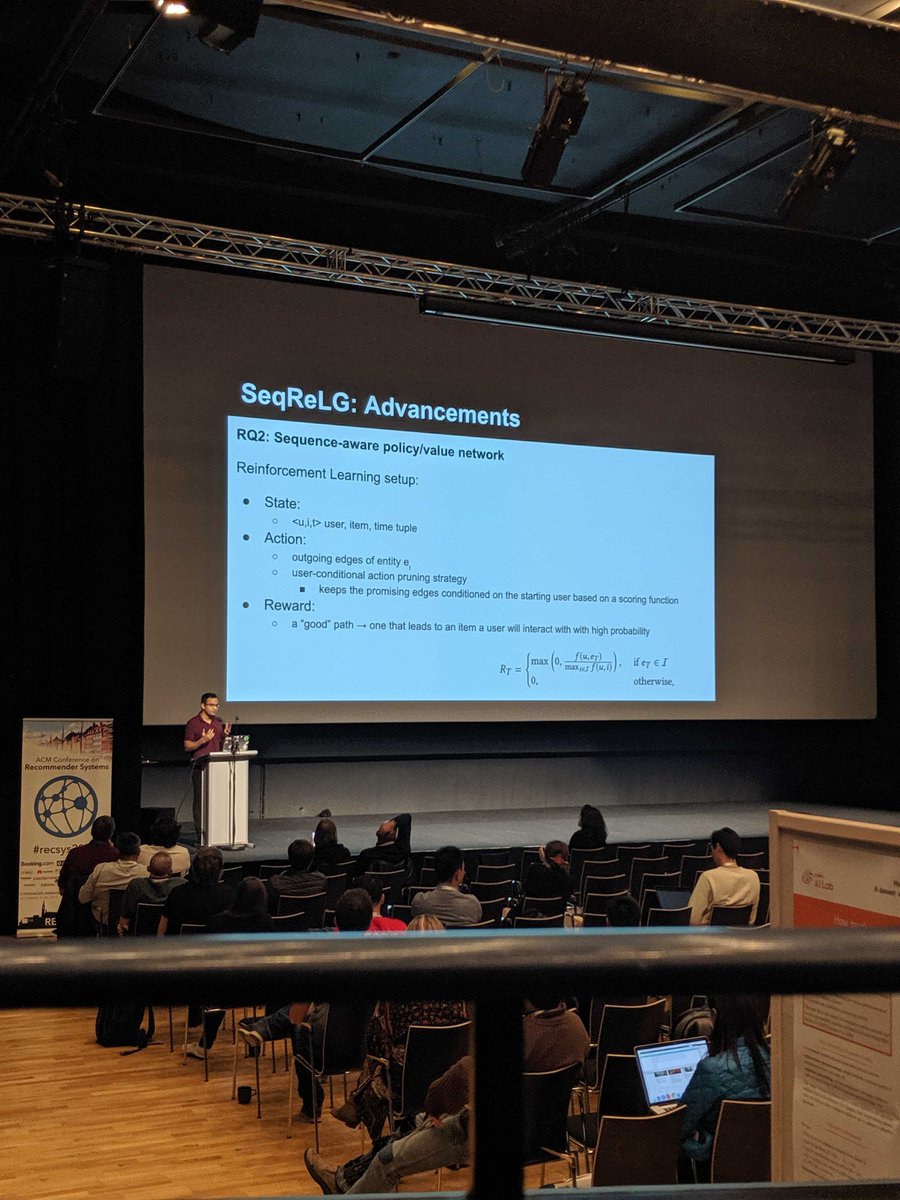 The image shows a person standing in front of a slide which mentions details of a sequence aware policy / value network