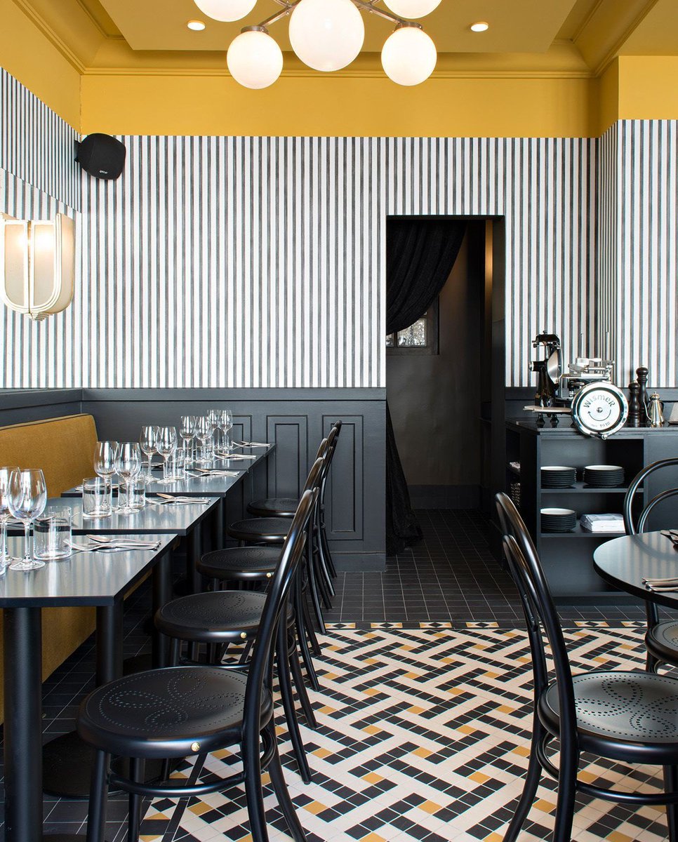 We love how Emilie Bonaventure has injected colour and personality into this Parisian restaurant with a mustard ceiling, an impressive tiled floor and monochromatic striped walls. ⭐