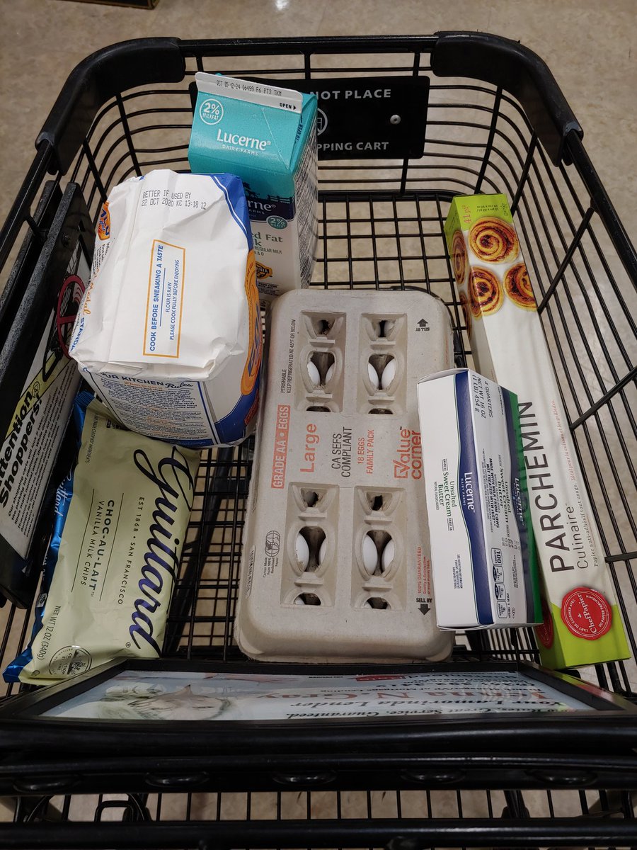 Shopping cart with eggs, flour, chocolate, butter, milk, and parchment paper