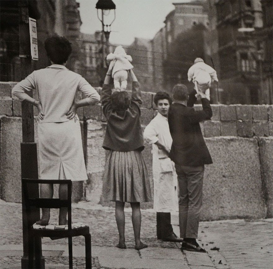 25- Des habitants de Berlin-Ouest élèvent leurs enfants au-delà du mur pour les montrer à leurs grands-parents restés à Berlin-Est (1961)