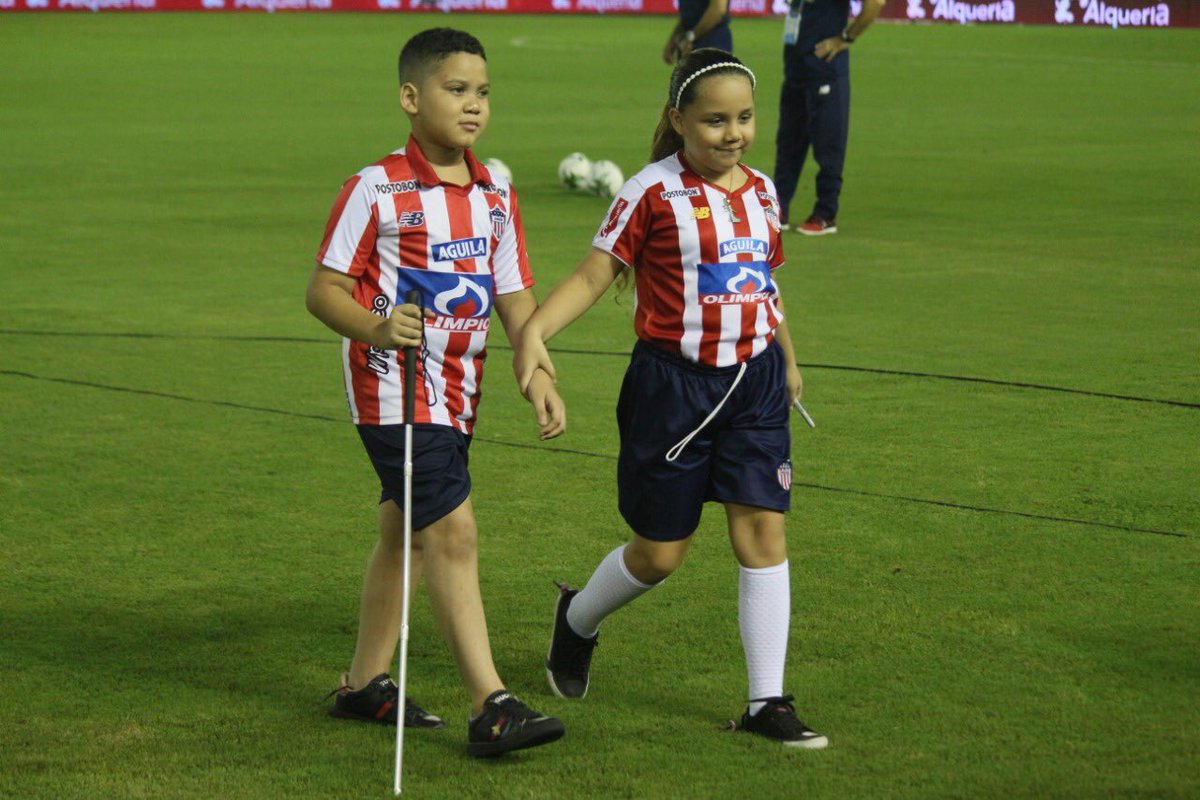 JuniorClubSA's tweet photo. 🙏🏻| Santiago cumplió su sueño. El niño invidente lleva los colores del equipo en su corazón y eso es suficiente para vivir la fiesta. Salió con Teo al campo y al final, se llevó su camiseta luego de que el goleador se la obsequiara. 

#VamosJunior🔴⚪️🔵 https://t.co/Ha52B5glxj