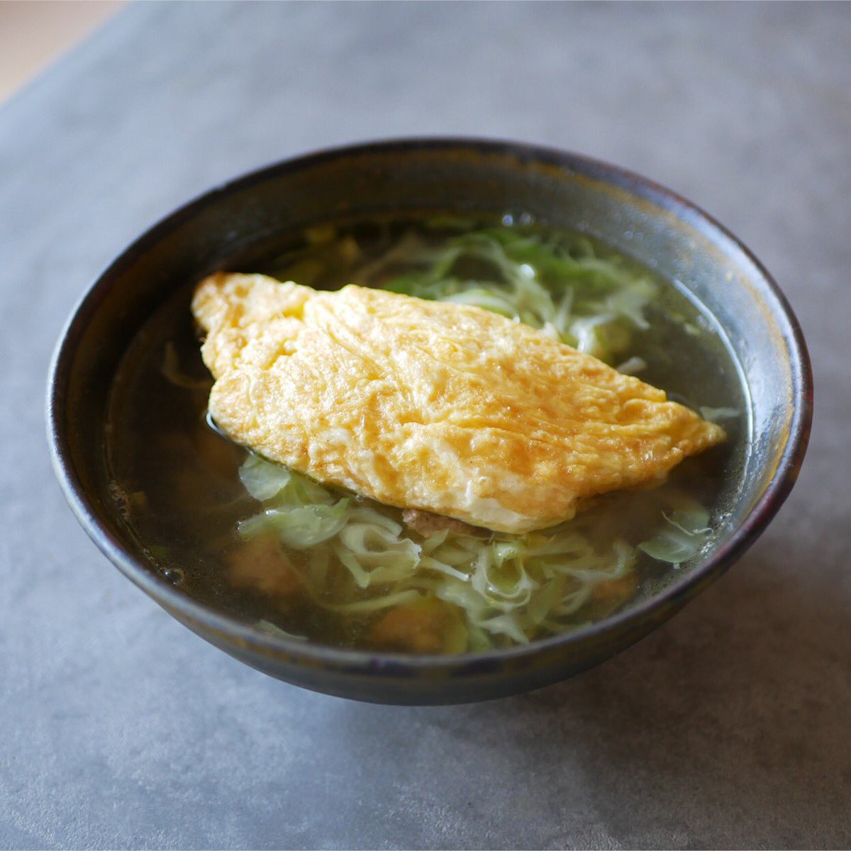 有賀 薫 千切りキャベツとひき肉のスープにオムレツのせて 卵1個分のミニオムレツをのせました ベースはひき肉と千切りキャベツ を醤油と胡椒で味付けした地味スープ たまごで一気に華やかです スープを吸ったオムレツがしっとりして そのまま食べるのと