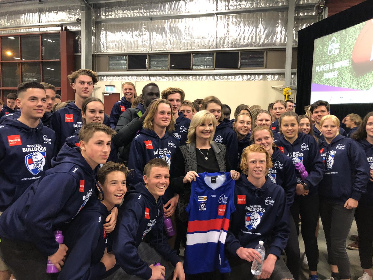 Mayor of Greater Shepparton Kim O’Keefe gets presented with a Western Bulldogs NGA top from the kids from AFL Western District Wimmera Mallee and Goldfields