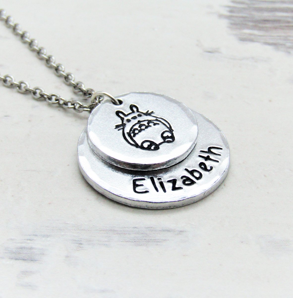 RogueBunnyUK's tweet photo. A new personalised totoro inspired necklace - Beautifully hand stamped using traditional methods >> https://t.co/NvxN2xJgpr #totoro #myneighbourtotoro #totorogifts #totorojewellery #studioghibli #totoronecklace #myneighbourtotoronecklace #spiritedaway #totoropendant #totorofan https://t.co/p0JujlXJ03