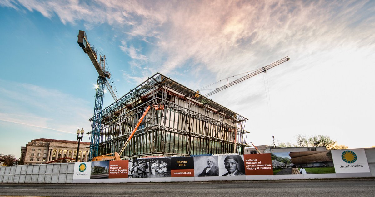 Exterior of museum building under construction with cranes and morning sky