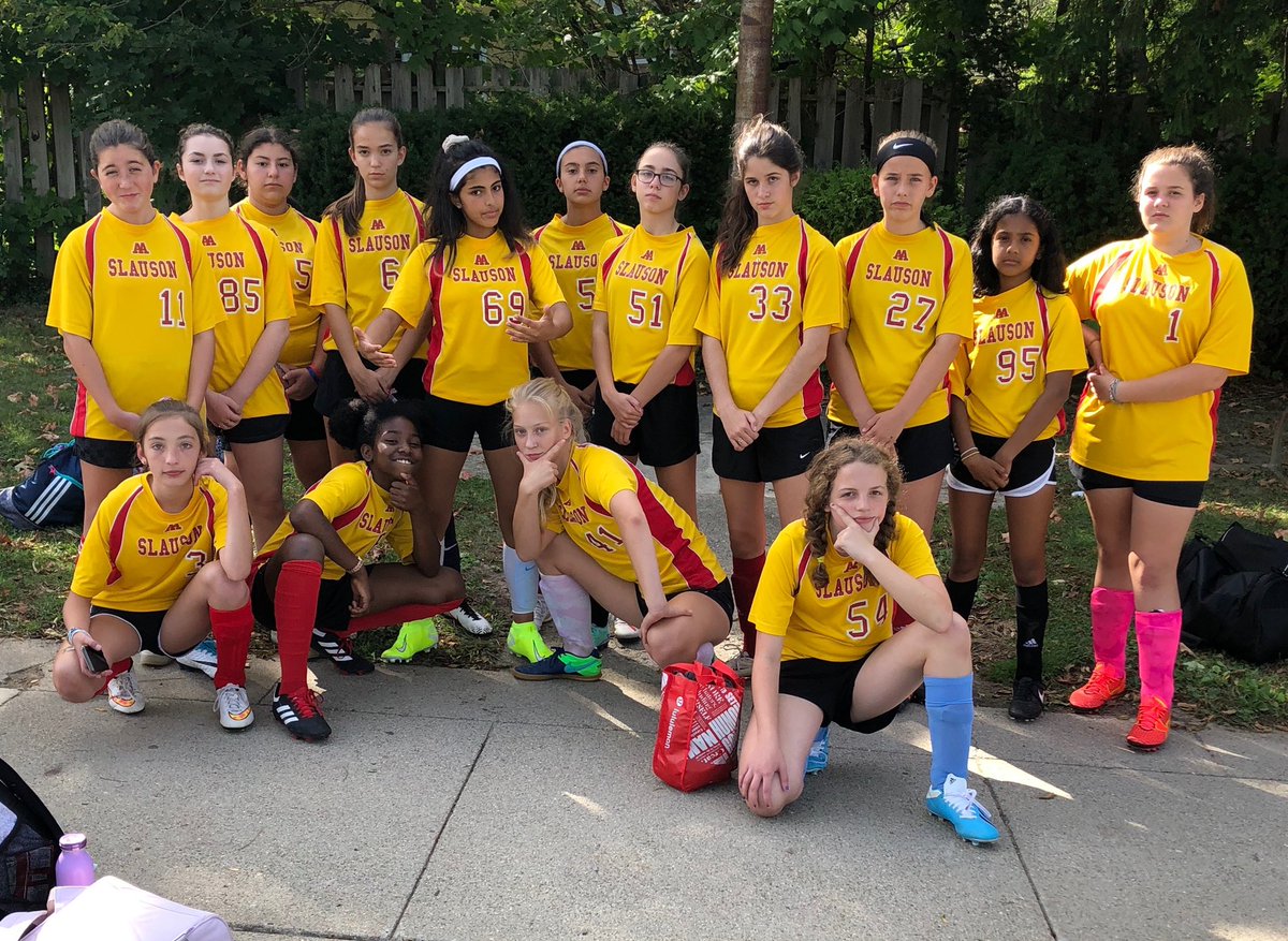 Girls soccer team having fun while waiting for the bus before their first game.