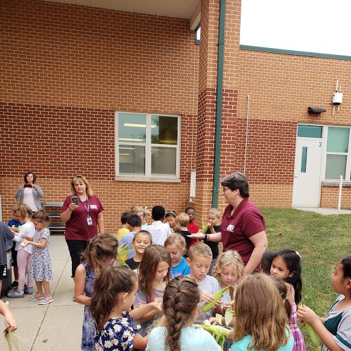 First grade students participated in our Farm to Table program today! They learned that some fruits and vegetables come from our local farms right to our cafeteria.  The students shucked corn to help prepare for tomorrow’s lunch and even tasted some local watermelon.