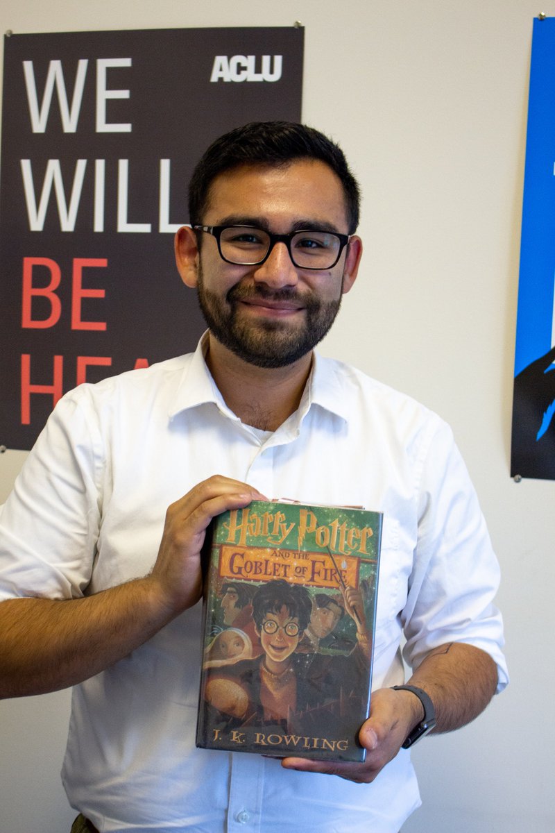 Pablo Anaya, ACLU of Maine Major Gifts Officer, holding a copy of Harry Potter and the Goblet of Fire