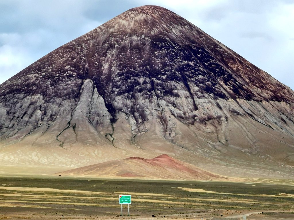 royxy's tweet image. 昨天旅途中比较魔幻风格的场景。经过一百多公里完全荒无人烟的贫瘠草原之后，在一座死火山脚下，突然出现了一块绿色的牌子。我们走近一看，是农行的“三农金融服务点”。那地方绝对是middle of nowhere ，放眼望去几十公里肯定没有人烟…农业银行这网点铺设做得也太到位了吧… #西北偏南