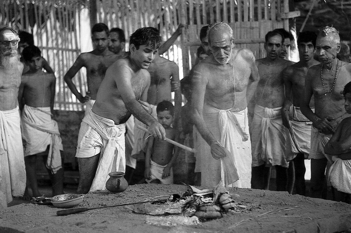 Before the introductory offering (prayaniyesti), the adhvaryu makes a libation with the sruva ladle, while Chermukku Vaidikan (C.V. Vallabhan Somayijipad) fans the fire.