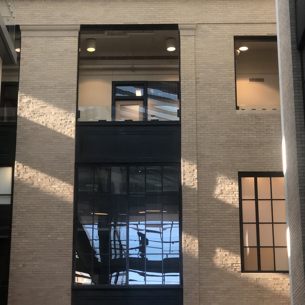 Light, materials, structure all come together here in the center of the pic. A student walking across the overpass was reflected to the grid glass windows that project the whole scene. The intégration of human, nature, and architecture brings wholeness to the scene.