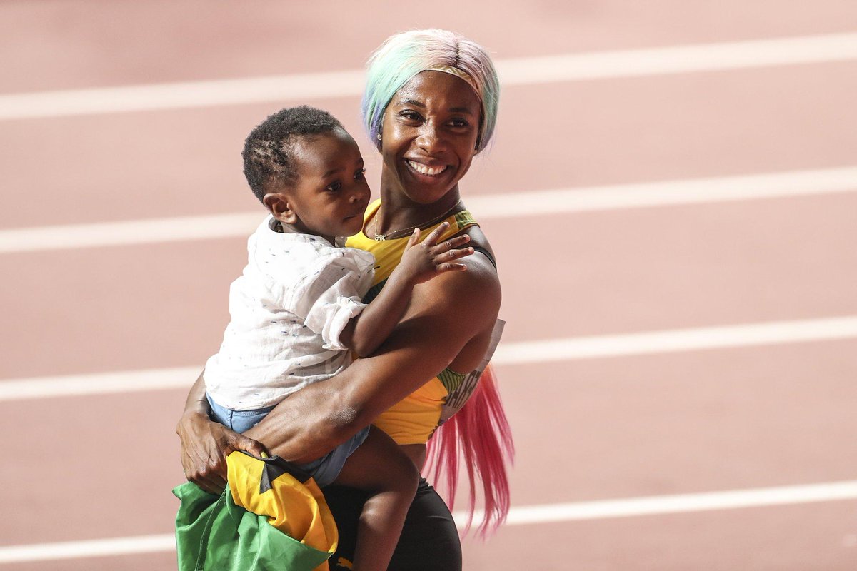 CopaAmerica2O2O's tweet photo. [In photos] - A rare kind of celebration -- mom with her son and her country's flag🇯🇲

@realshellyannfp of #Jamaica competes during women's 100m final during the IAAF World Athletics Championships 2019 at the Khalifa Stadium in #Qatar https://t.co/2GgkZvF7GR