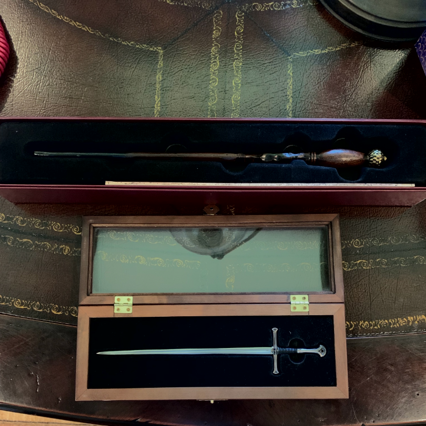 KCushman1's tweet photo. The sword Anduril from Lord of the Rings and a wand from Olivander's stay on my  desk at all times. A key ring charm of Dobby the elf and another of Reepicheep the mouse stay on my purse at all times. I find it odd that I don't write fantasy... #amwriting #kathryncushman https://t.co/XrZG4R7iUz