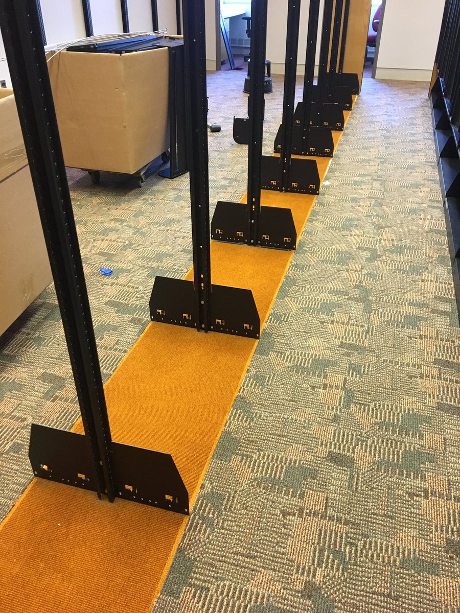 mandosally's tweet photo. The old orange carpet rises up from beneath the stack shelving. Changes on the way! #LibraryRefresh @UMMSLibrary https://t.co/ZzkUqWxNZr