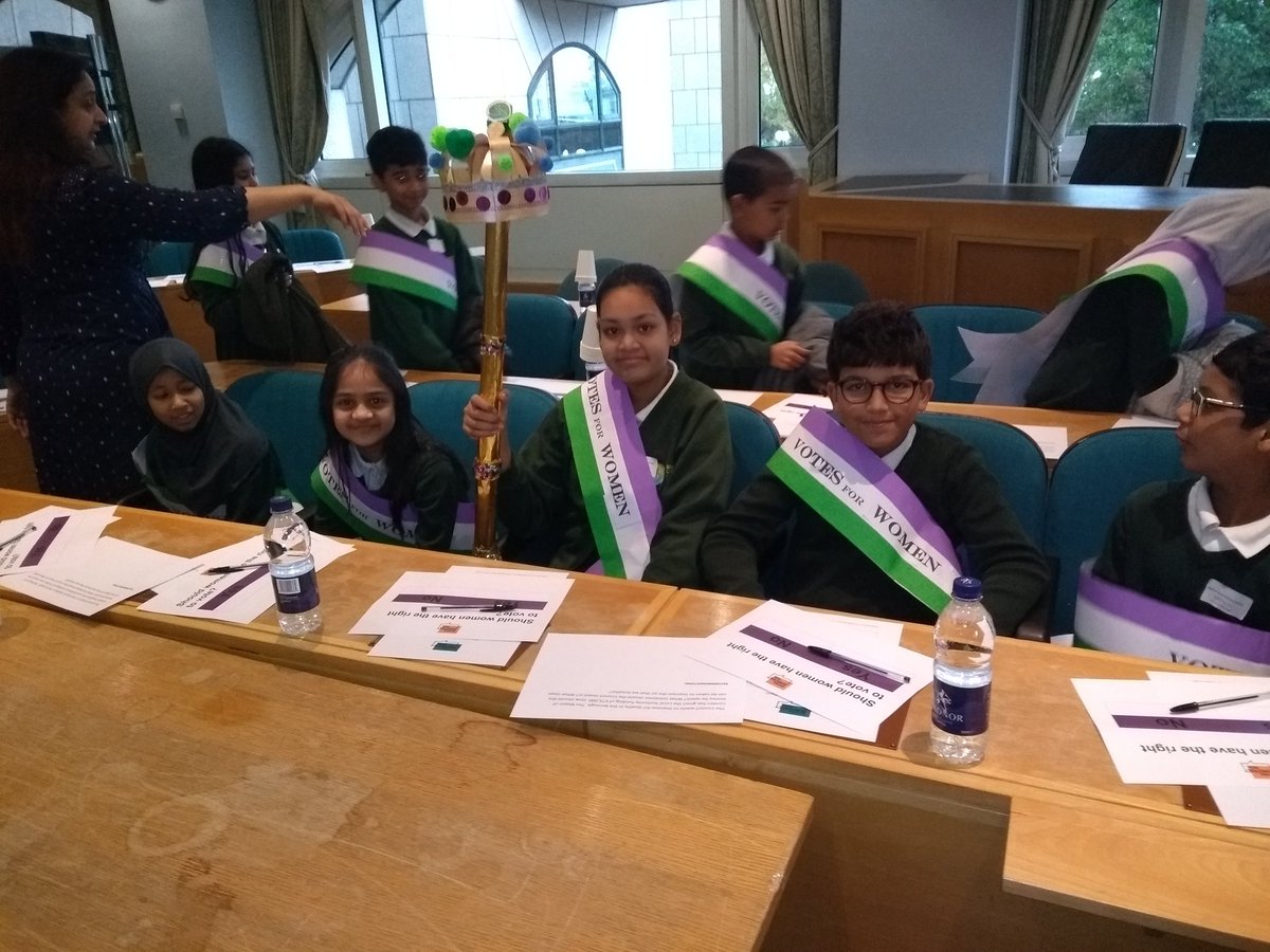 TowerHamletsNow's tweet photo. At national democracy week in the Town Hall #NDW19 Speaker @Victoria_Obaze explains the significance of her traditional costume including her chains of office or "bling." Marion Richardson and Bigland Green primary school children have plenty of questions too. @cabinetofficeuk https://t.co/rFEqklUyY1