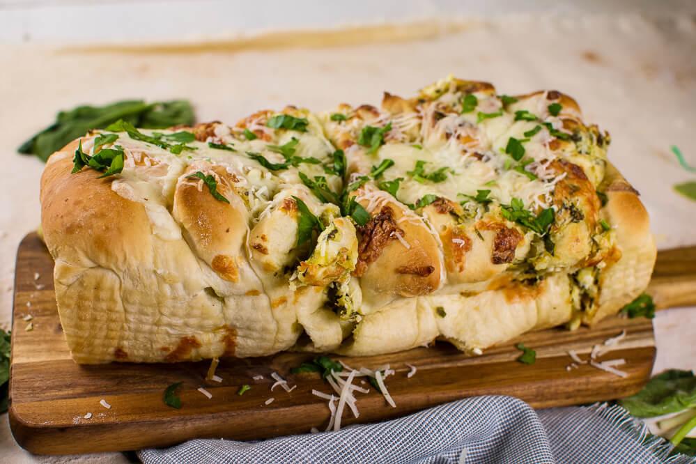 #ad Spinach Artichoke Pull Apart Bread is an easy, cheesy, appetizer, or side dish! Serve it with soup, salad, or pasta! <a href="/rhodesbread/">Rhodes Bake-N-Serv</a> #frozendough #breadrecipe #pullapartbread #spinachartichokedip bit.ly/2owLNB9