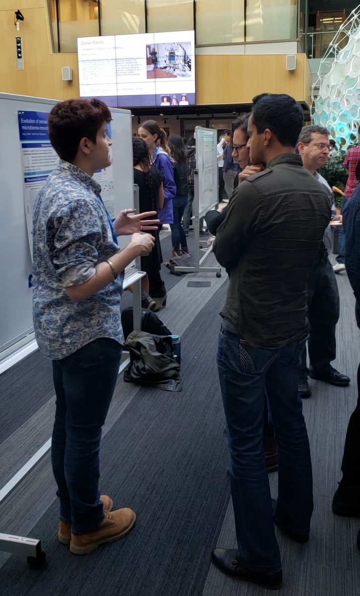 Guests watch a presenter explain her work.