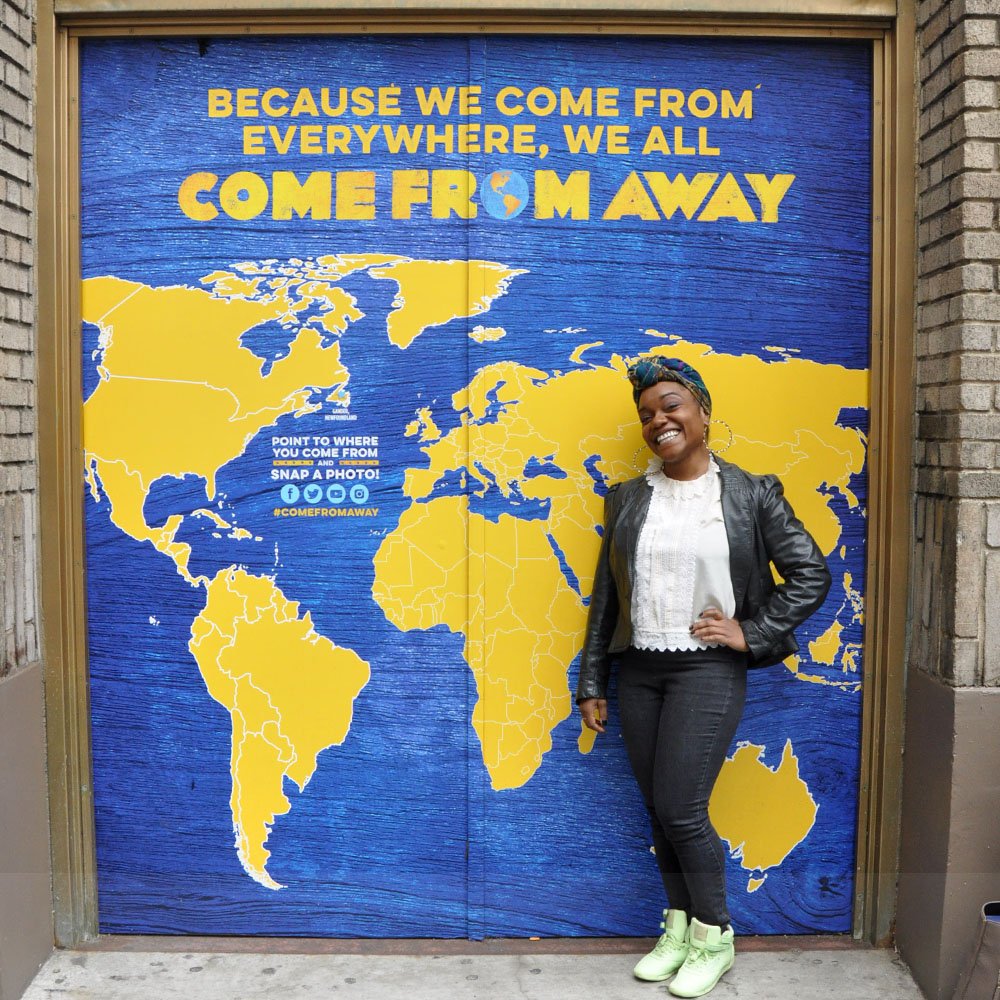 Kenita Miller smiling in front of the door at the Schoenfeld Theatre