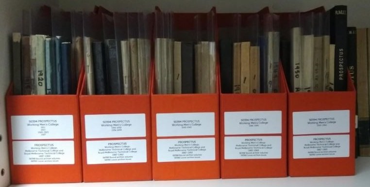 publications in red magazine boxes on a shelf