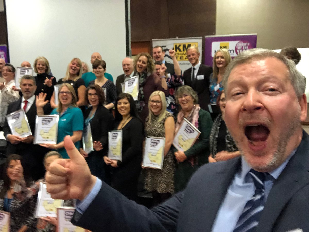 SimonDolbyKent's tweet photo. Winners of #KentCharityMark at #KMForum celebrate with event host Simon Dolby. @InspireSchools1 @streetspaceUK @KrestonReeves @SocEntKent @KentCommunity https://t.co/ztRS7X2wWt