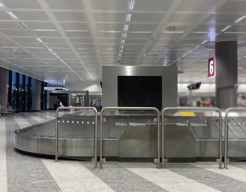 Our tour of Milan includes a baggage claim, a train, and the grandeur of Milan Central Station.