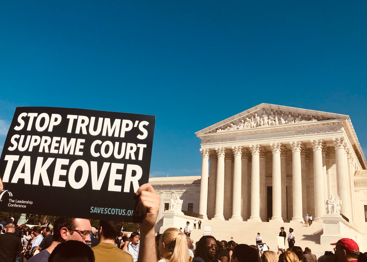 A sign in front of the Supreme Court says "Stop Trump's Supreme Court Takeover."