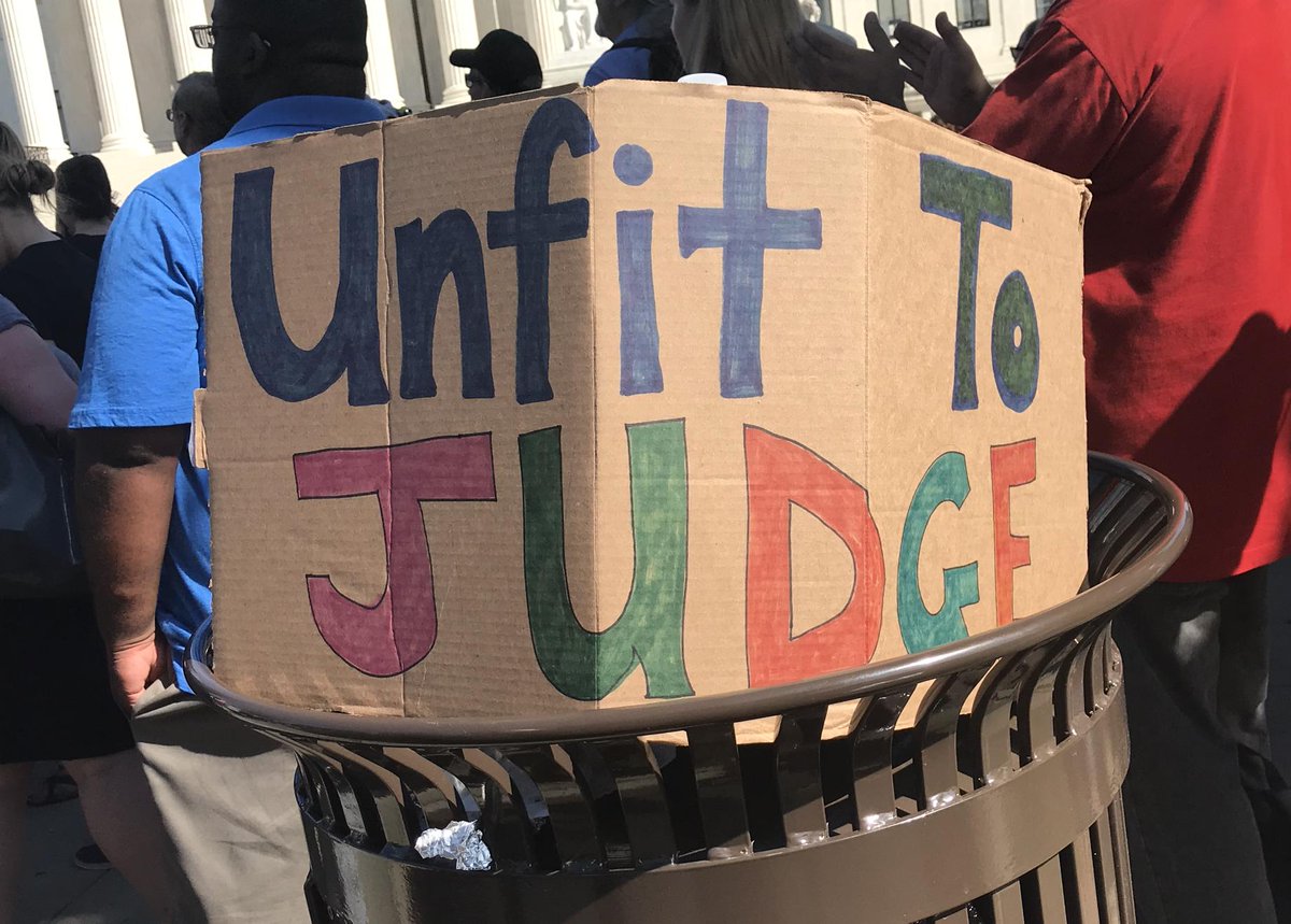 A protest sign reads "Unfit to Judge."