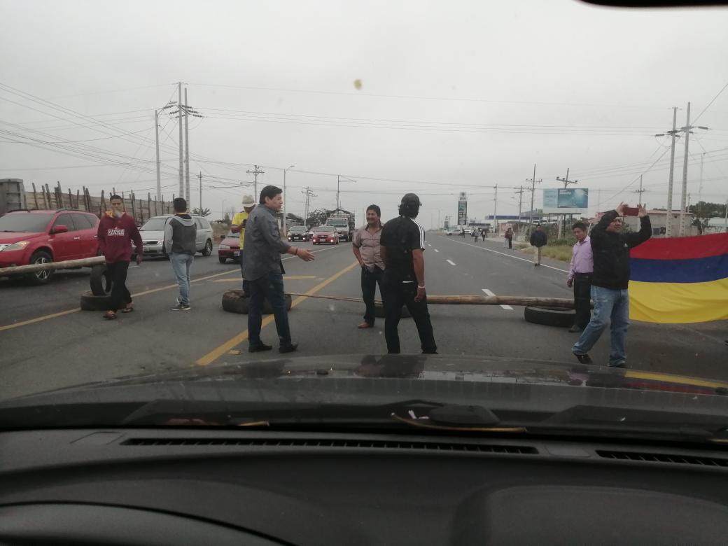 Joc_Gabriel's tweet photo. Unos cuántos pelagatos acaban de cerrar el paso Santa Elena - Gye a la altura de la entrada a Chanduy por la Gasolinera. El que viste de negro con gorra y de espaldas es el "líder", la policía está en la Gasolinera y los de Tránsito detrás mío. @Cupsfire_gye https://t.co/lLnpceegPI